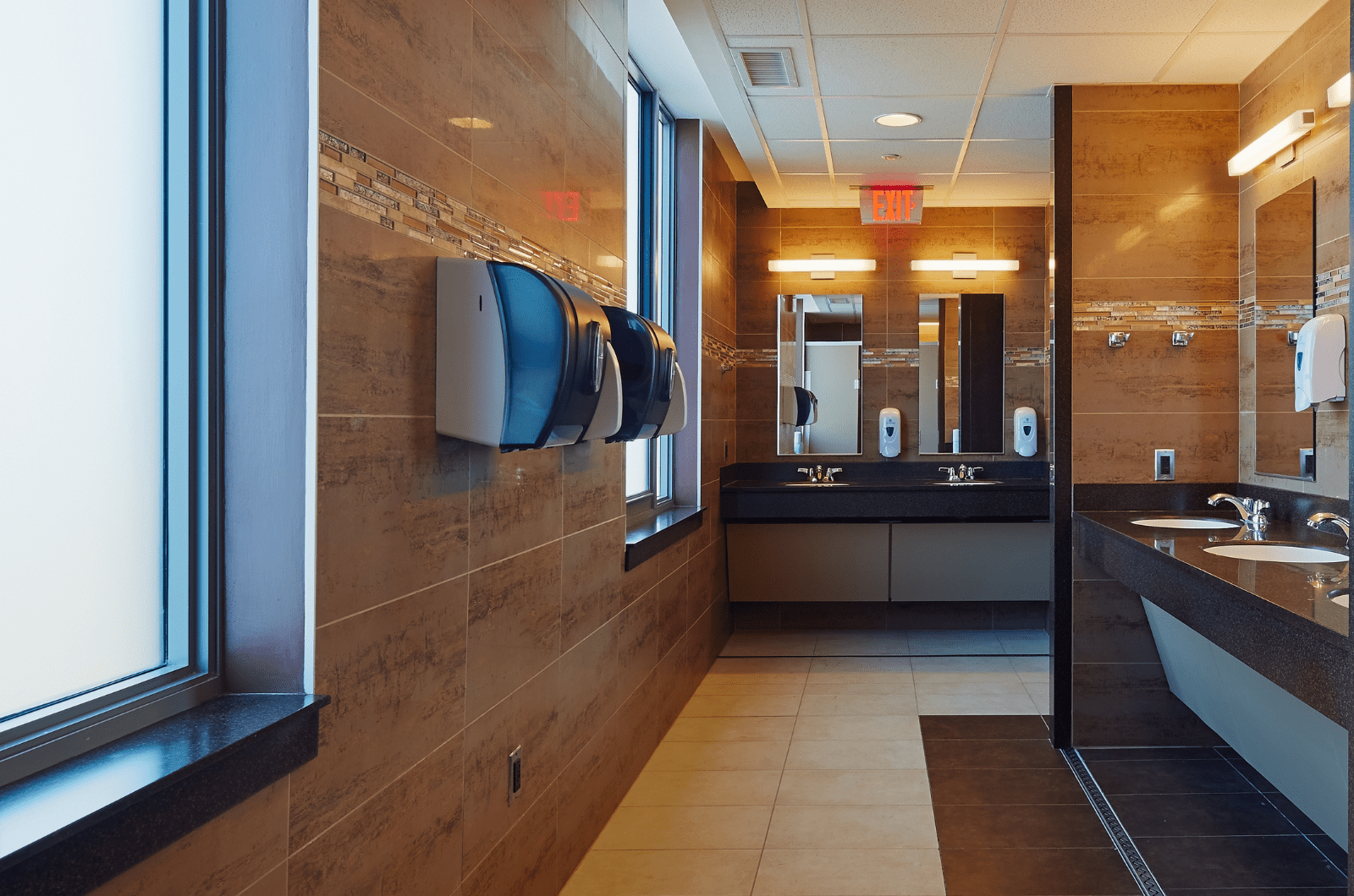 inside bathroom hallway with sinks and hand dryers visible