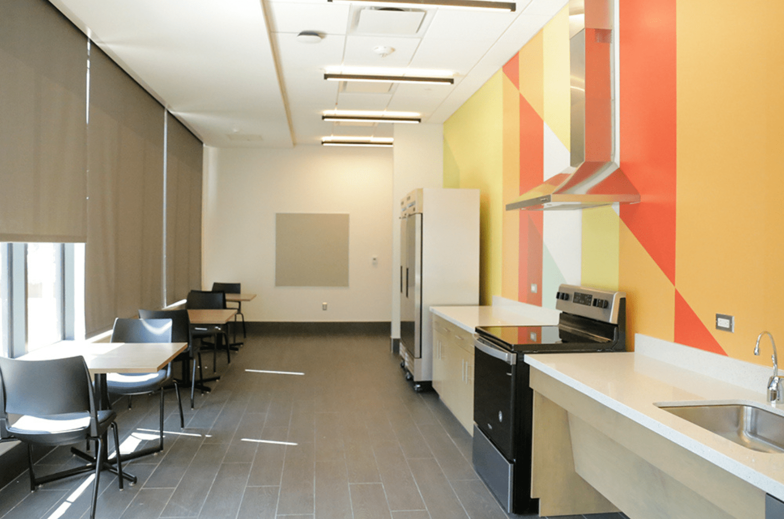 kitchen area with fridge, stove, sink and eat-in tables