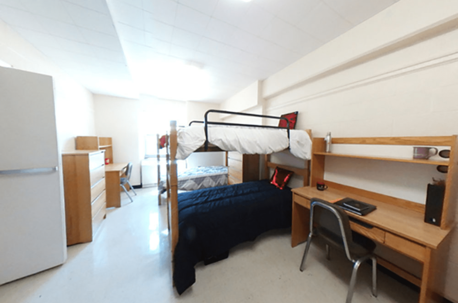 quad room with two bunk beds and a desk int the foreground