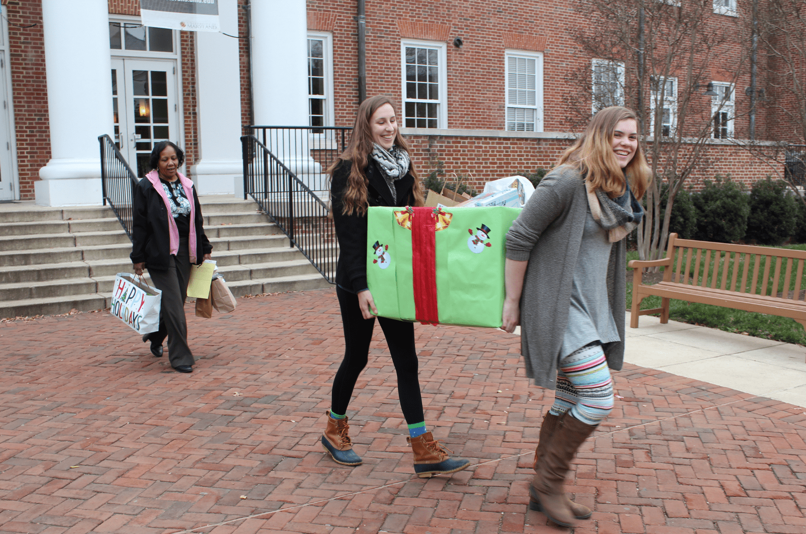 three terp toy drive volunteer carrying box of toys to donation center