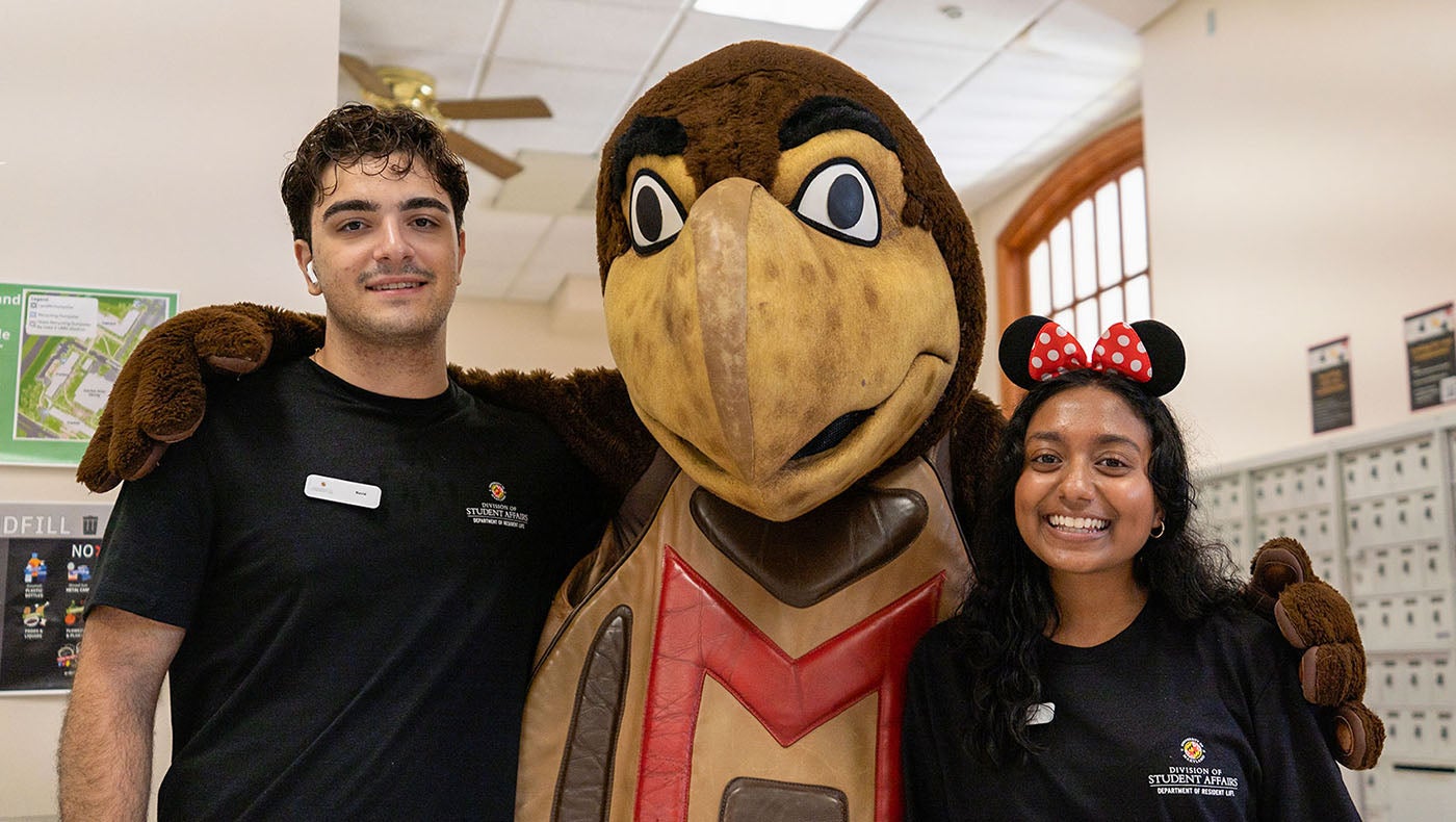testudo mascot with arms wrapped around two students