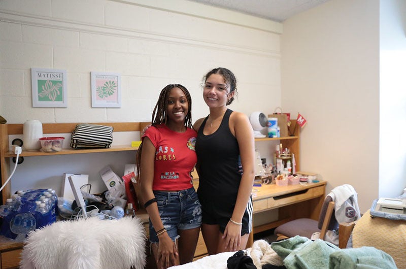 two students posing in their room during move-in
