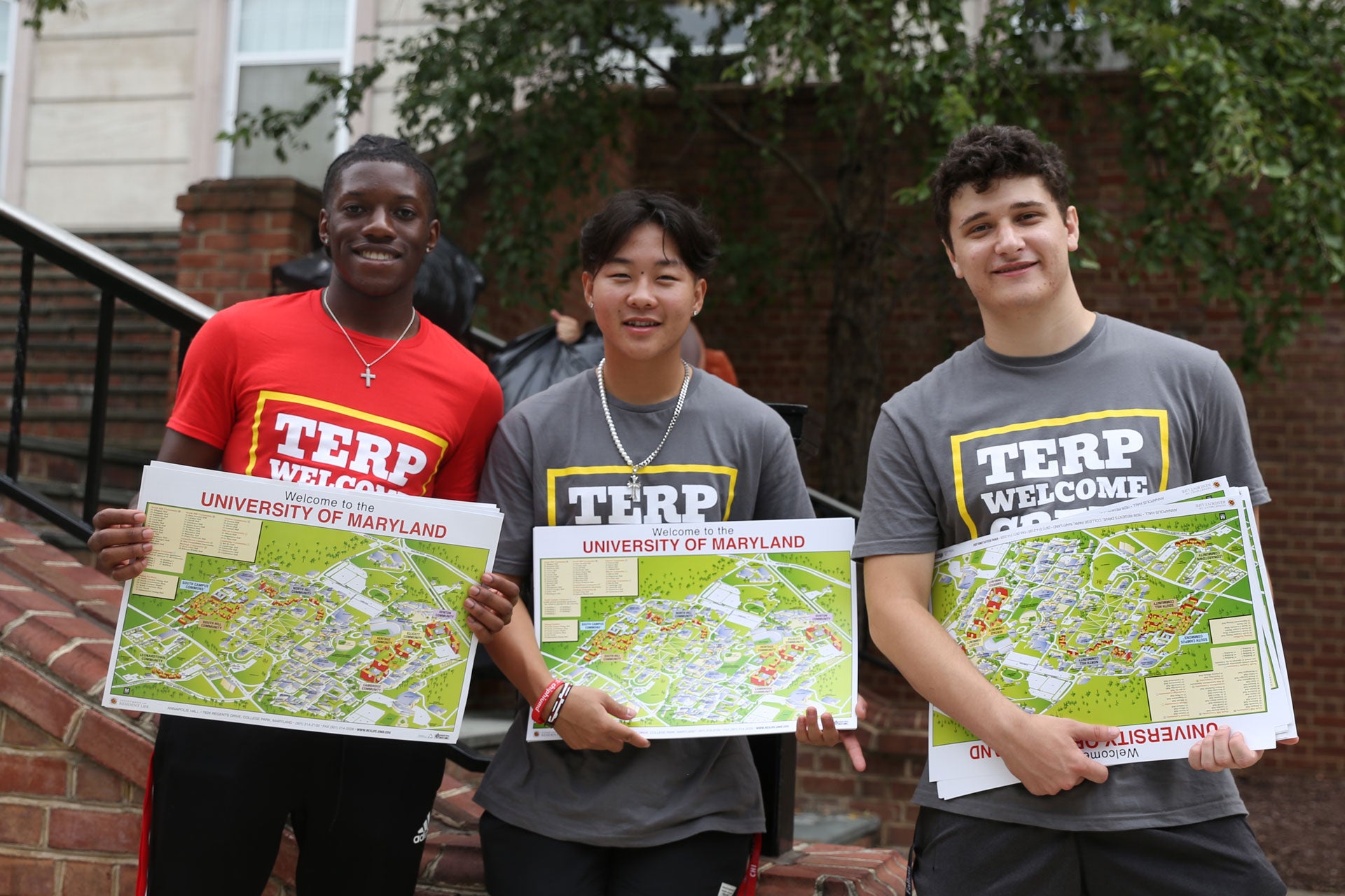 three TWC volunteer with campus maps for move-in