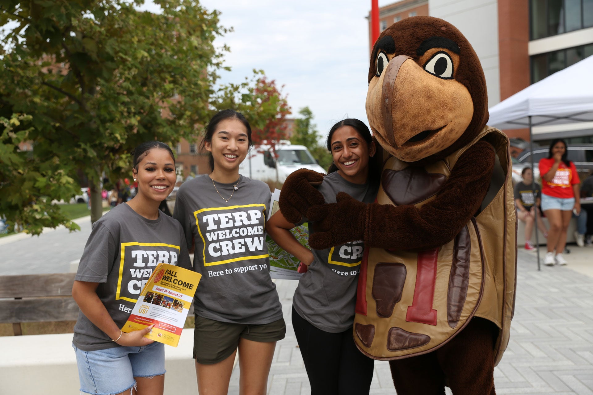 three TWC volunteers with Testudo mascot during move-in