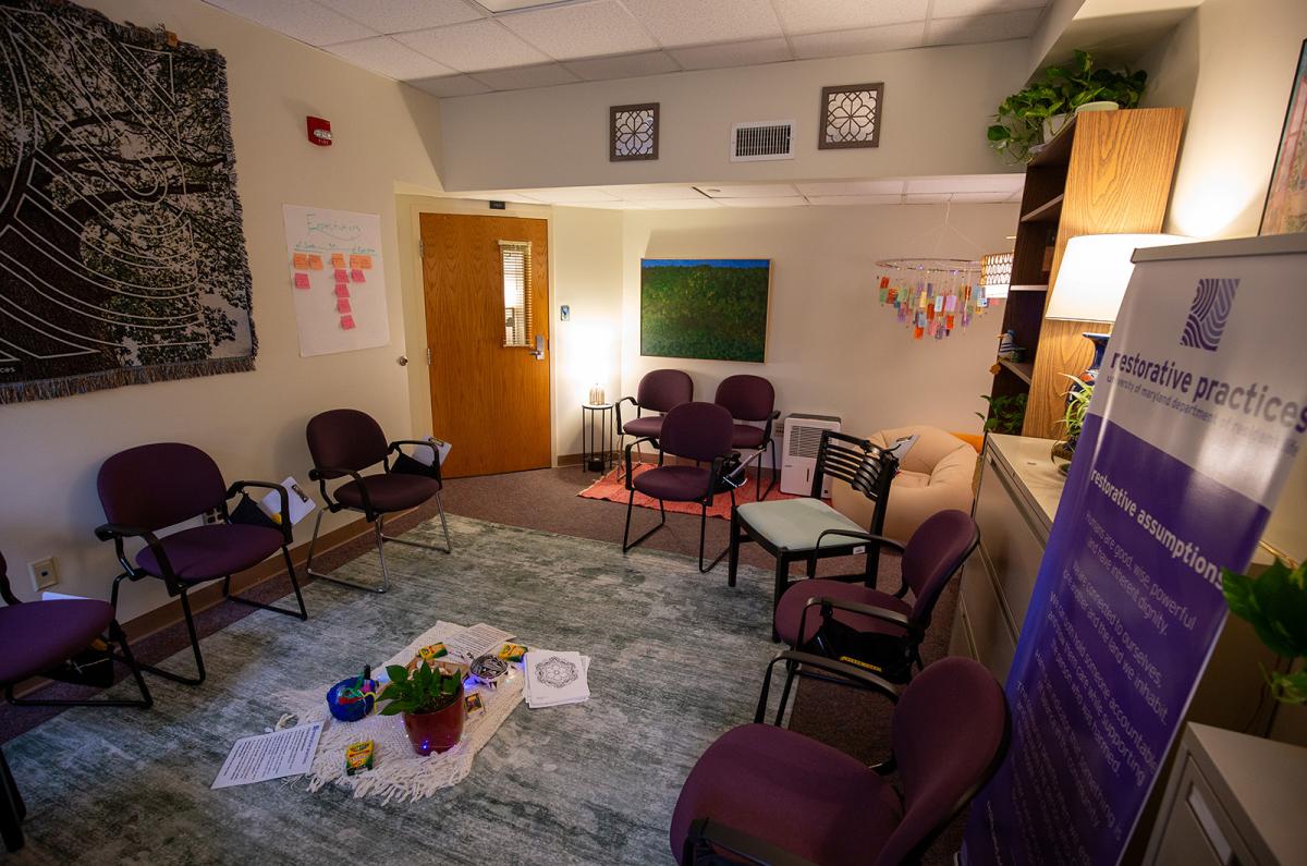 the new Restorative Circle space, a room with a circular chair arrangement with a centerpiece in the middle and cozy lights.