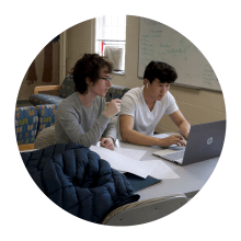 two male students studying in dorm common area 