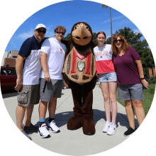 parents and two students with testudo mascot during opening
