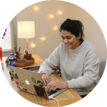 student working on laptop at a desk in residence