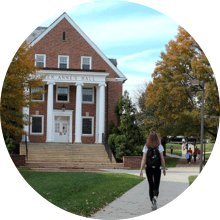 student walking in front of Queen Anne's Hall