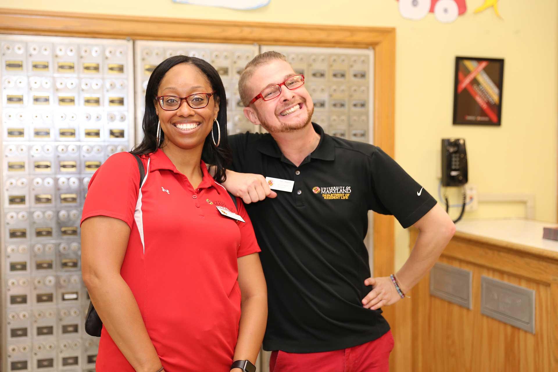 two smiling members of the resident life staff in a residence hall