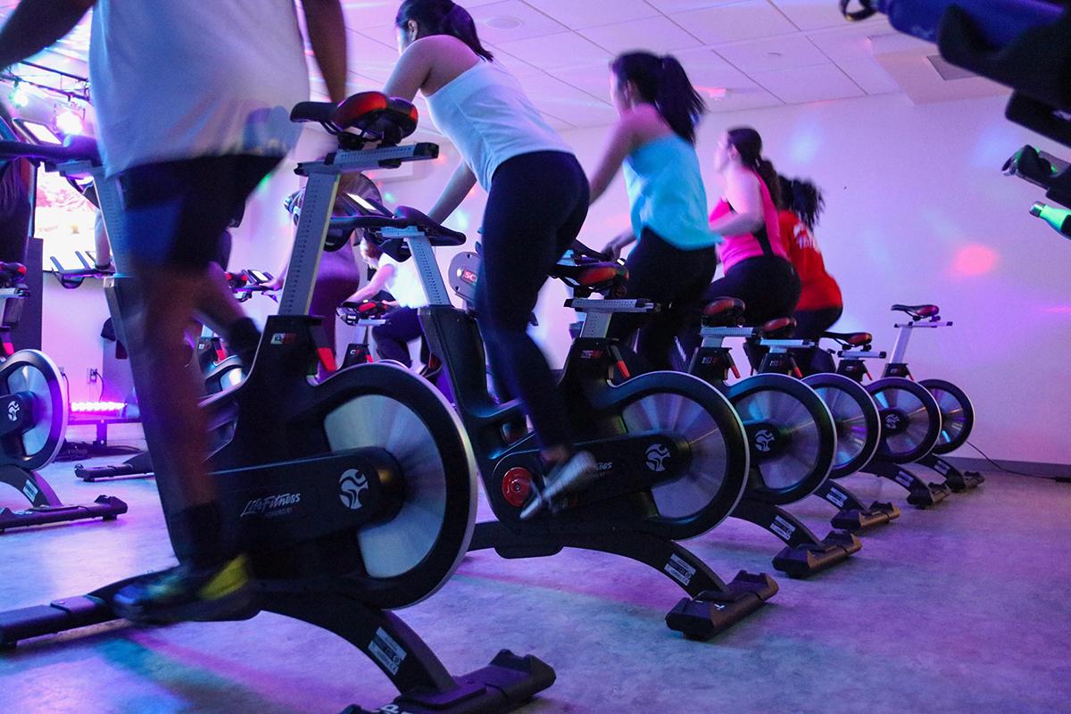 row of students on stationary bikes in a spin class