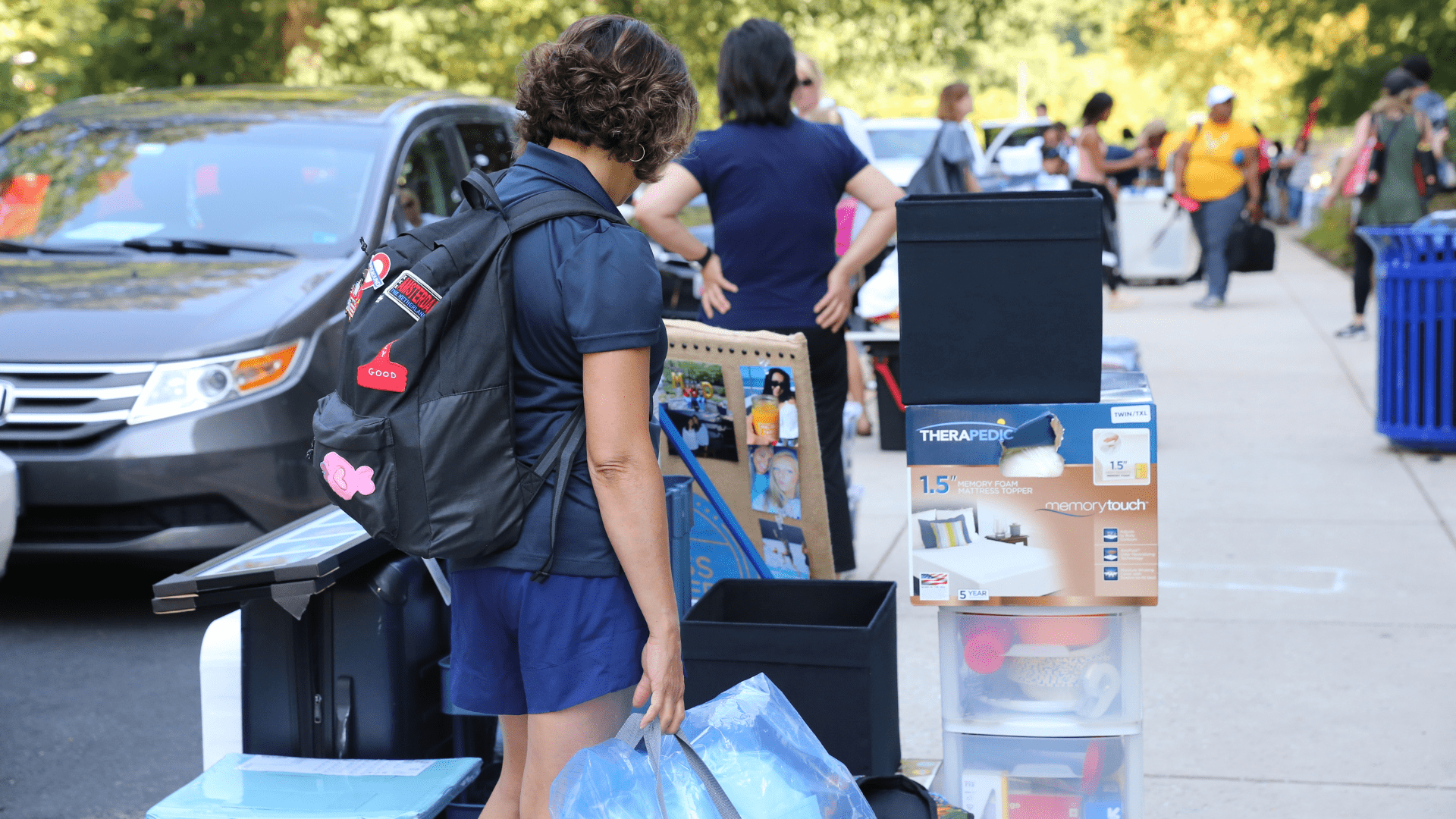 student with personal belongings outside residence hall on move-in day