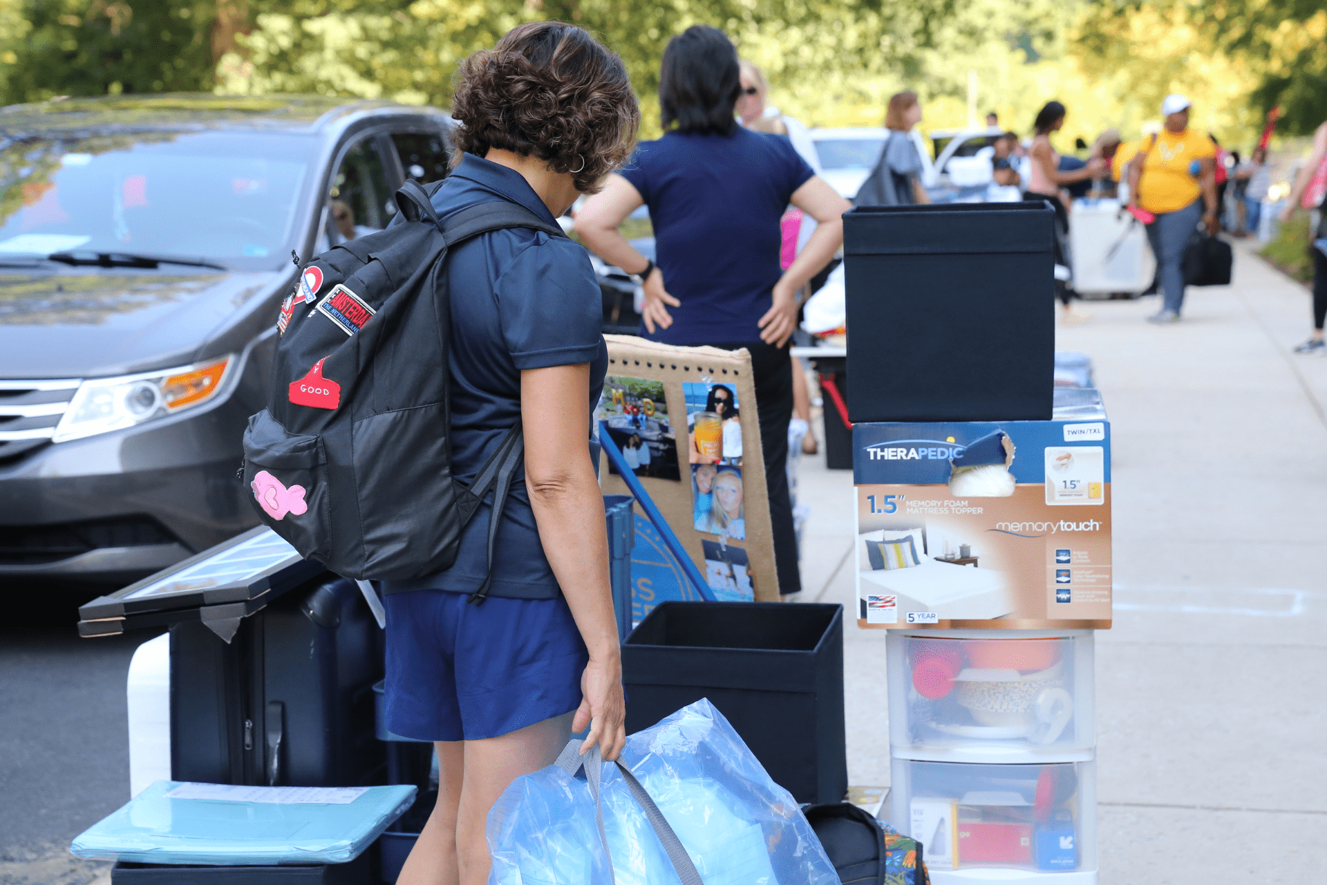 student with personal belongings outside residence hall on move-in day