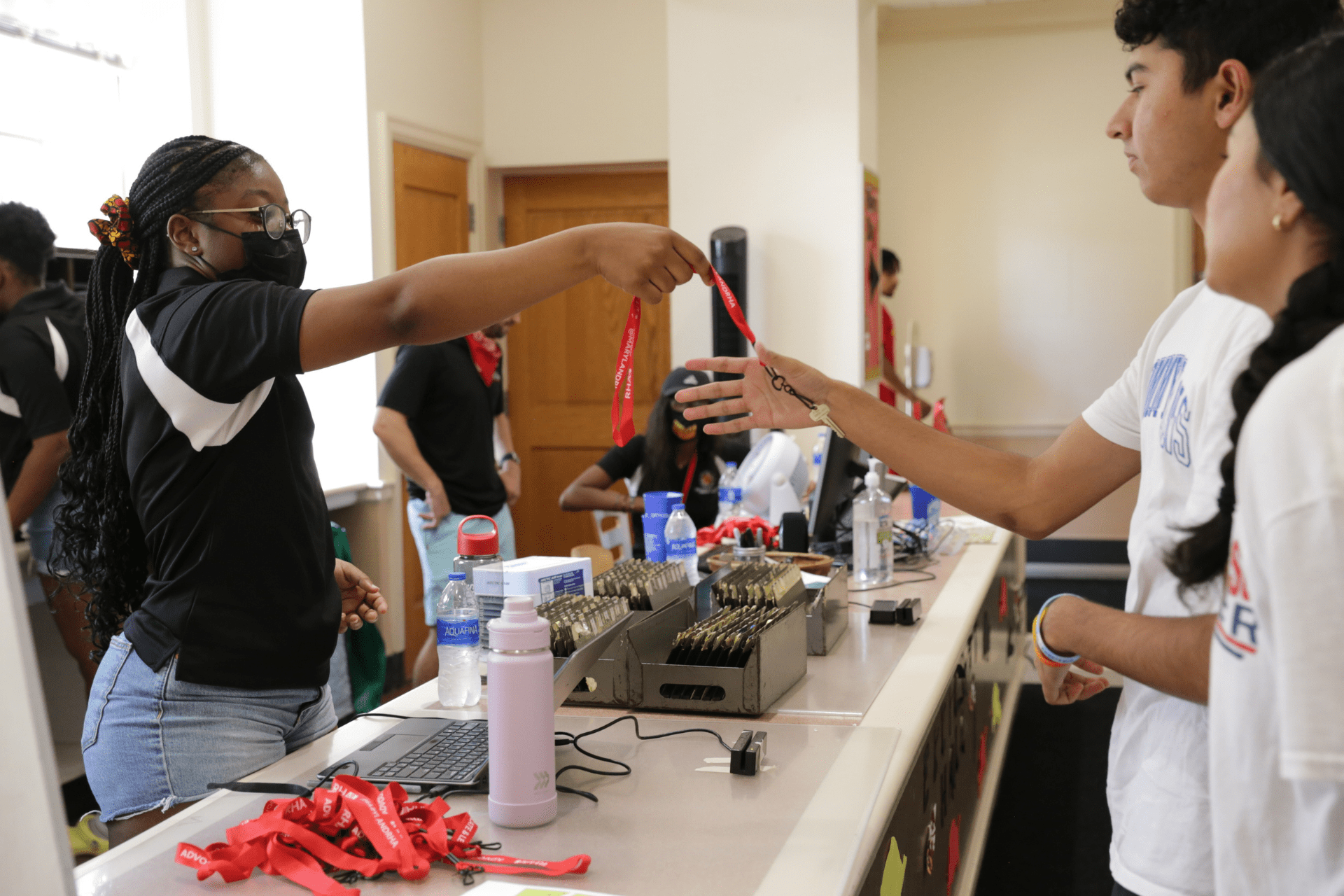 student grabbing keys from the service desk community assistant