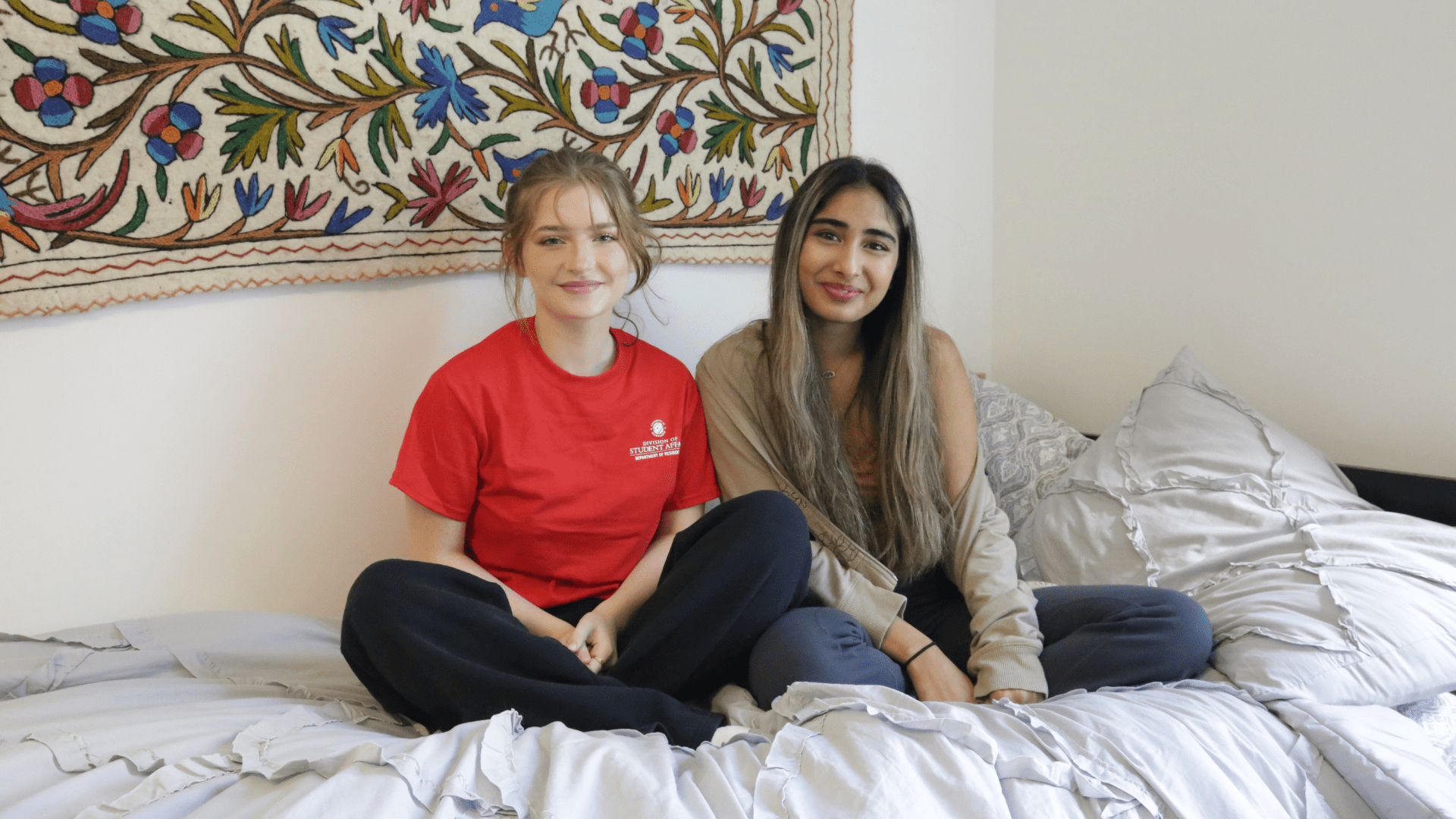 two roommates sitting on a bed