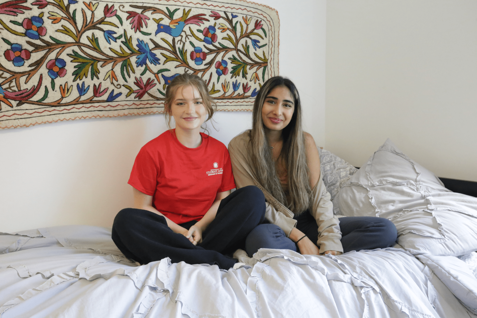 two roommates sitting on a bed