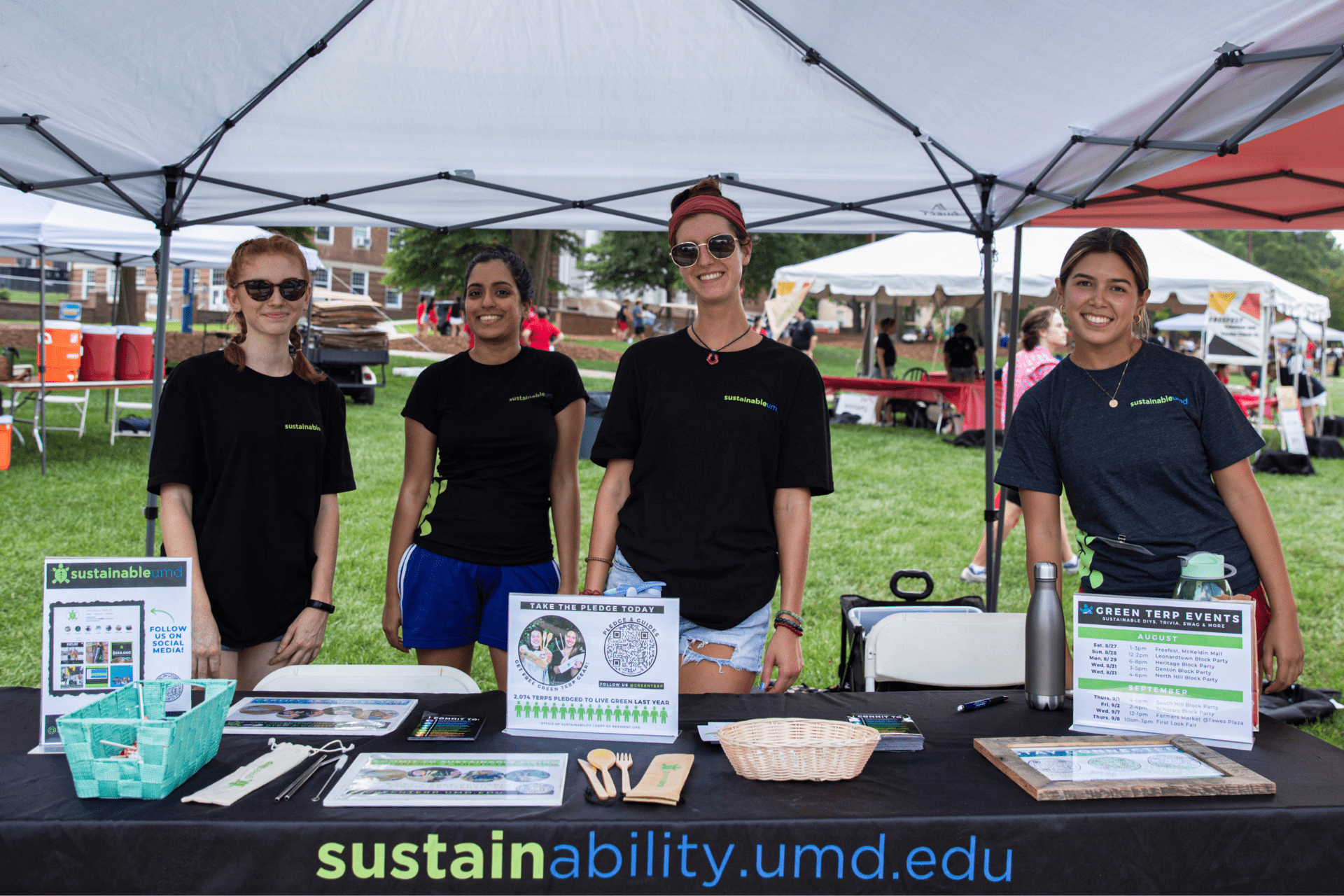 four students working at the sustainability tent during freefest