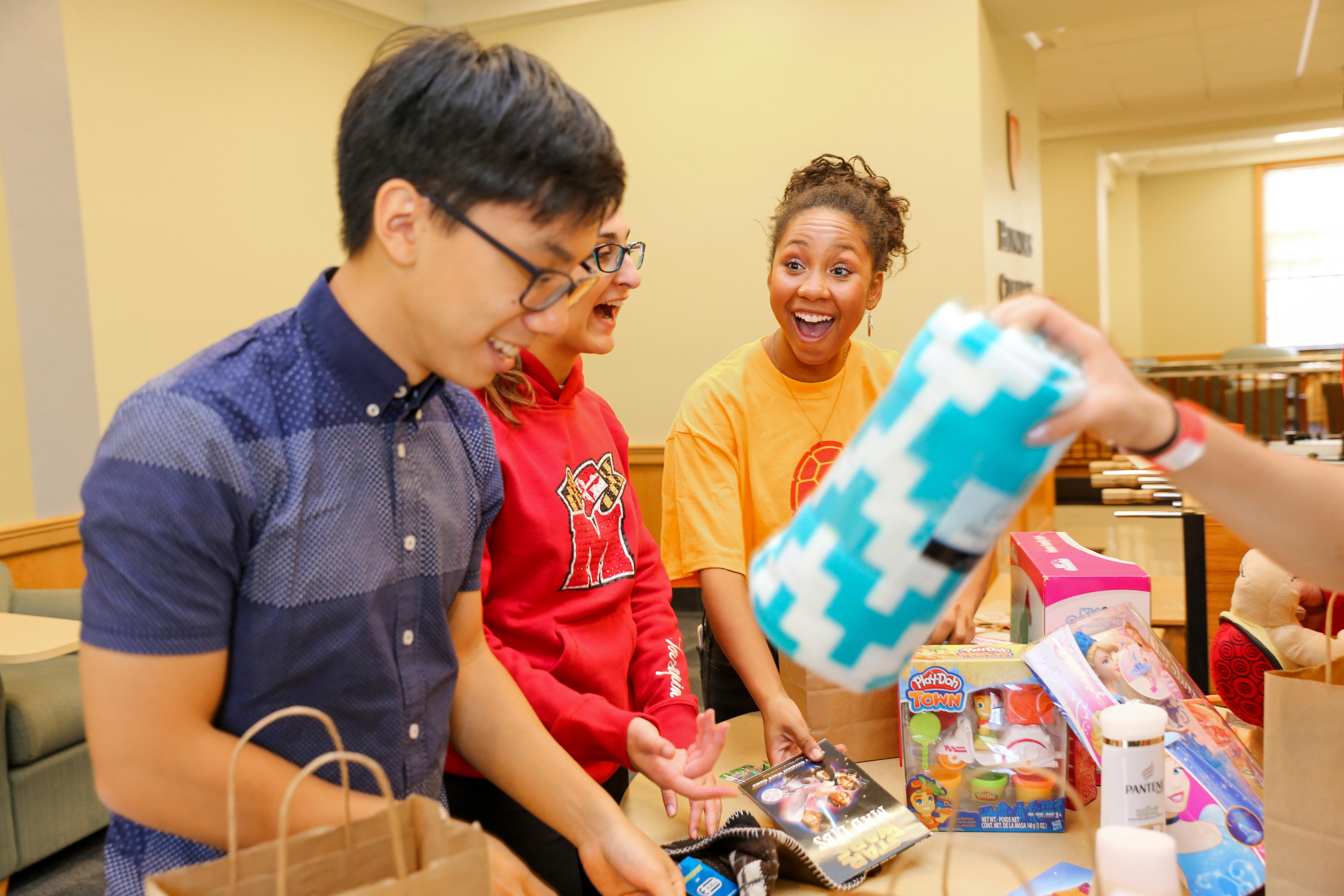 three students sorting gifts for the terp toy drive