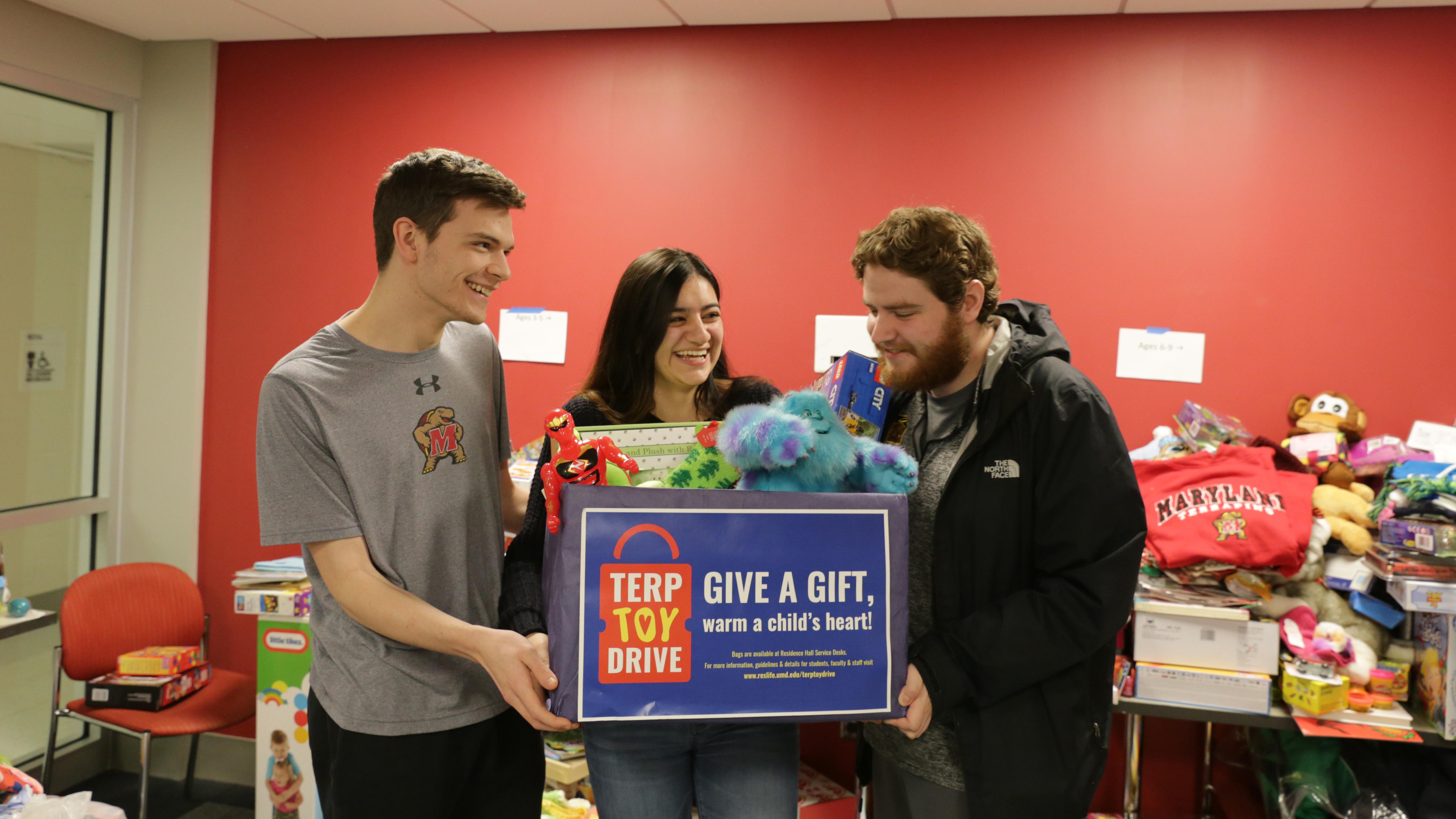 three students sorting gifts for the terp toy drive