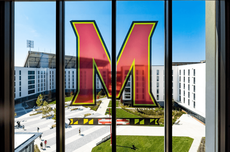 M Bar logo decal sticker on a window of Pyon-Chen Hall overlooking Heritage Plaza.