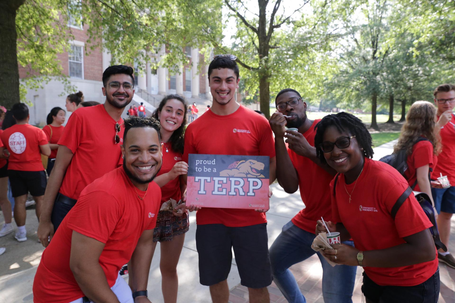 group of resident assistants wearing red shirts and holding up a proud terp sign