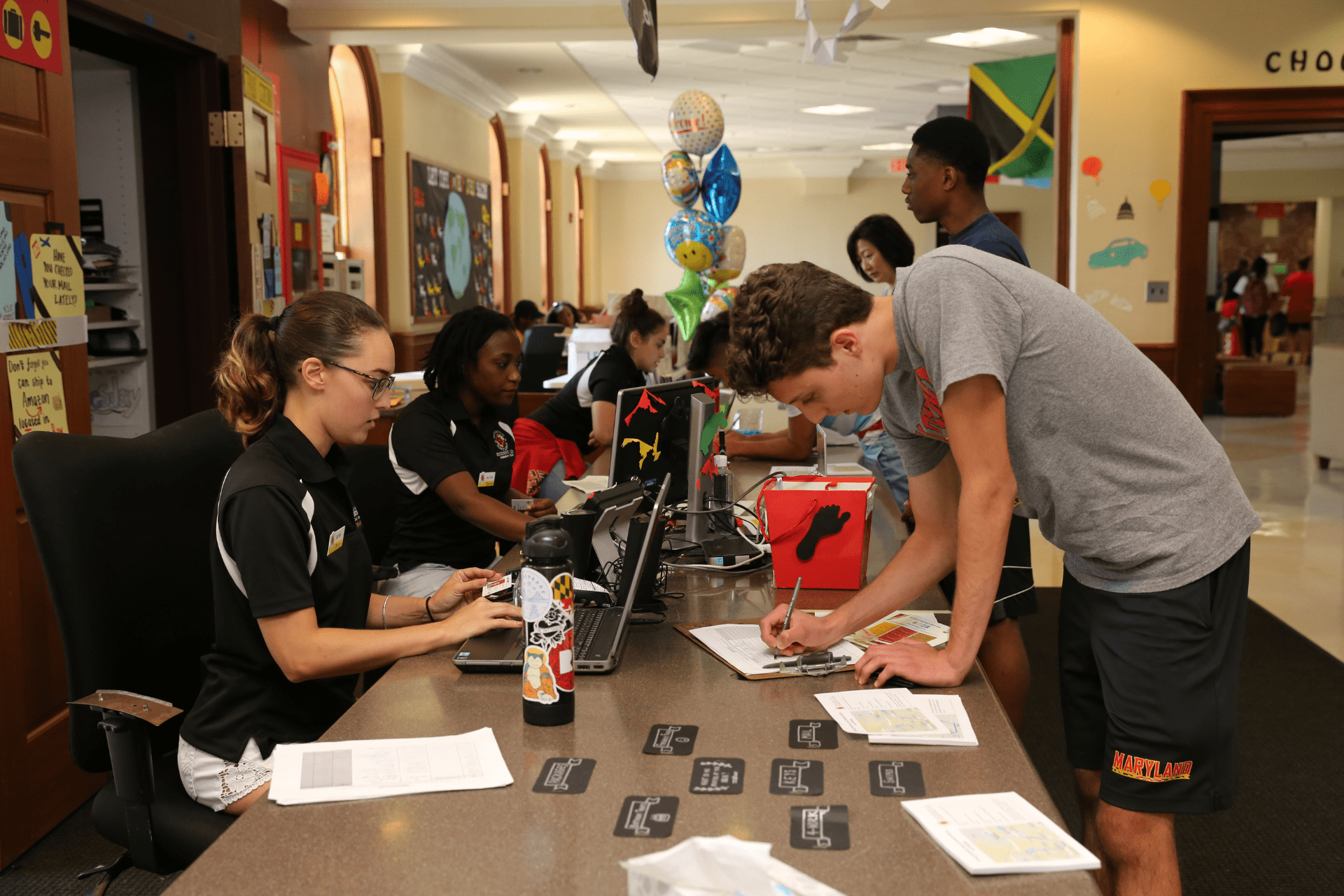 student signing paper at a residence hall service desk