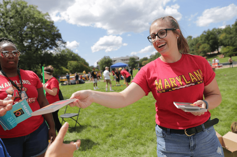 student handing out first year books during fall fest