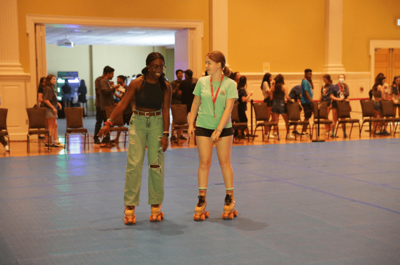 students rollerskating indoors during fall welcome event