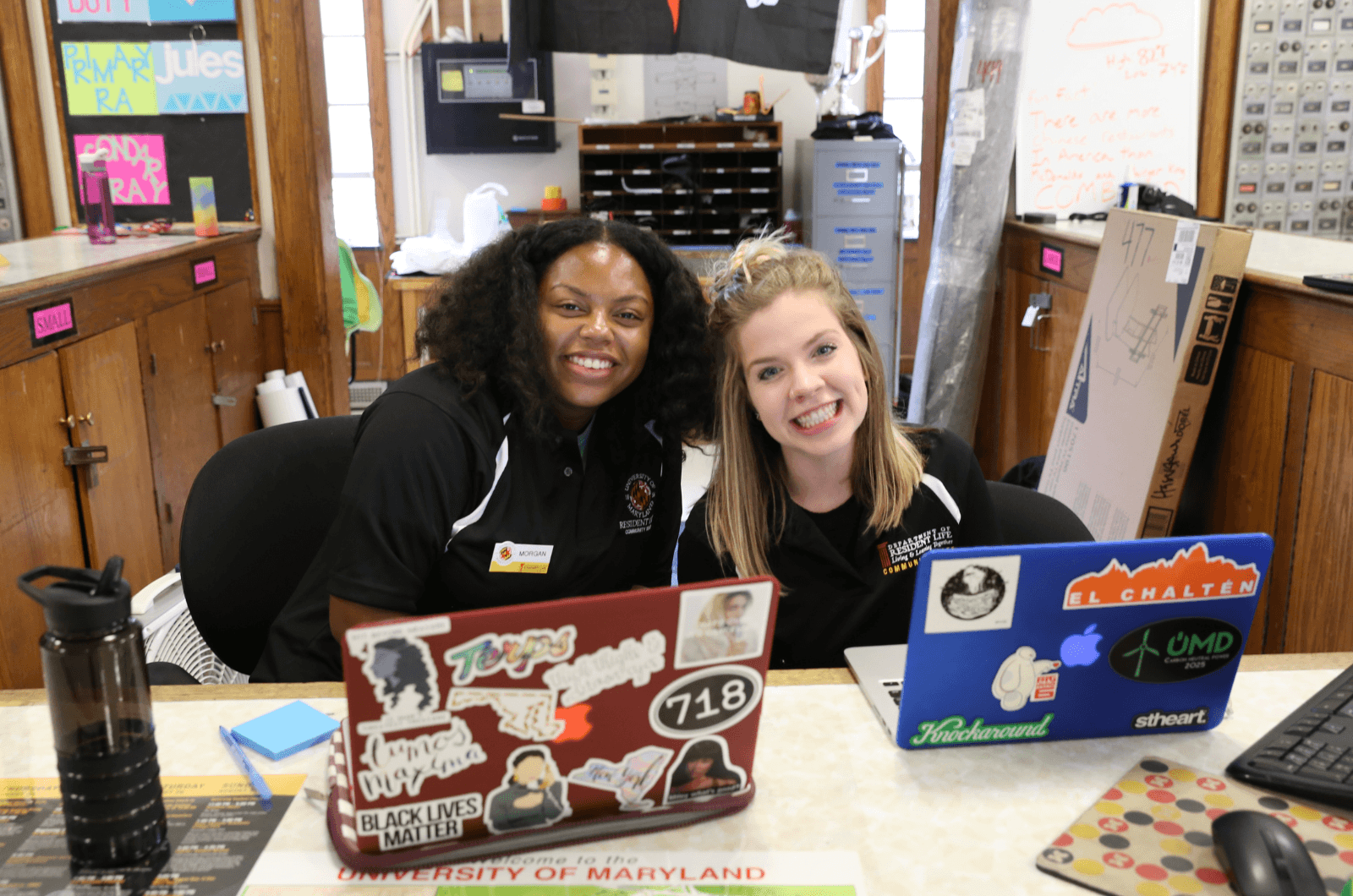 two female students working behind a service desk