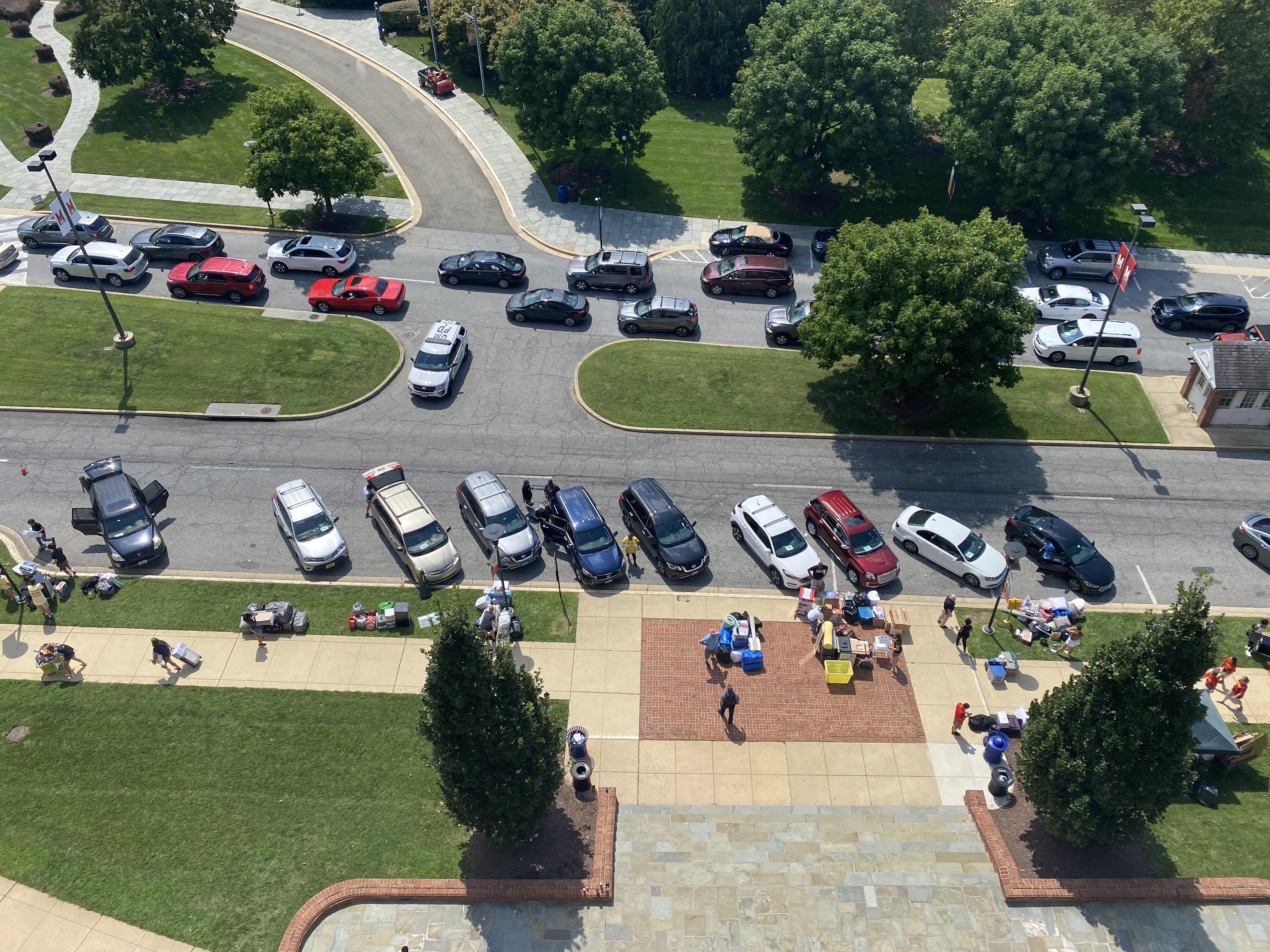 aerial view of cars parked in loading/unloading zone in front of a residence hall during moving day