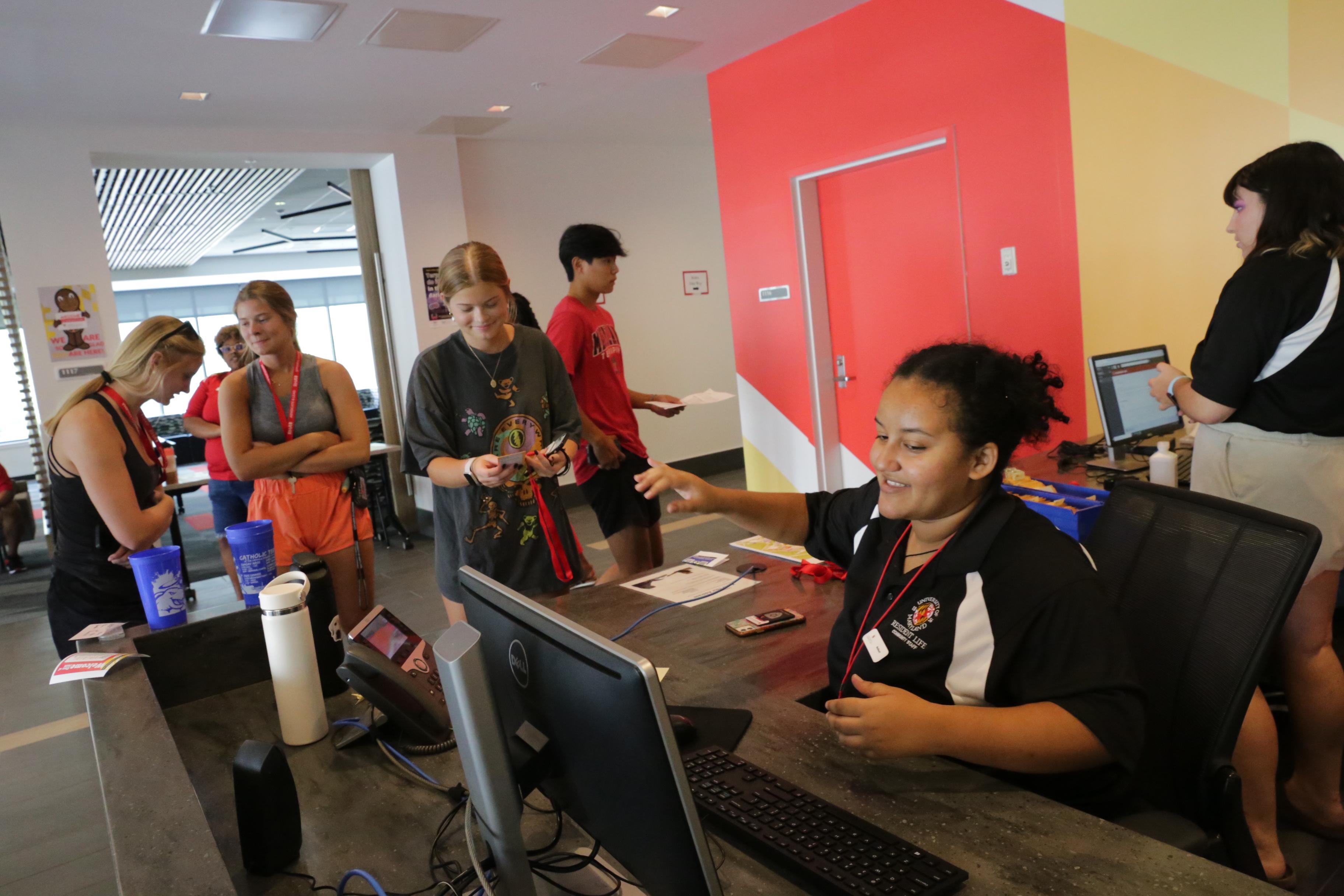 community assistant checking in new student residents at a service desk during move-in