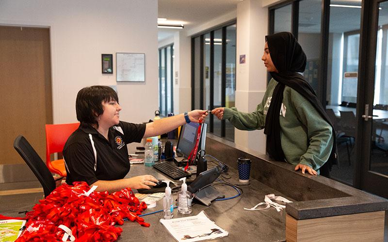 student retrieving key from service desk during move-in