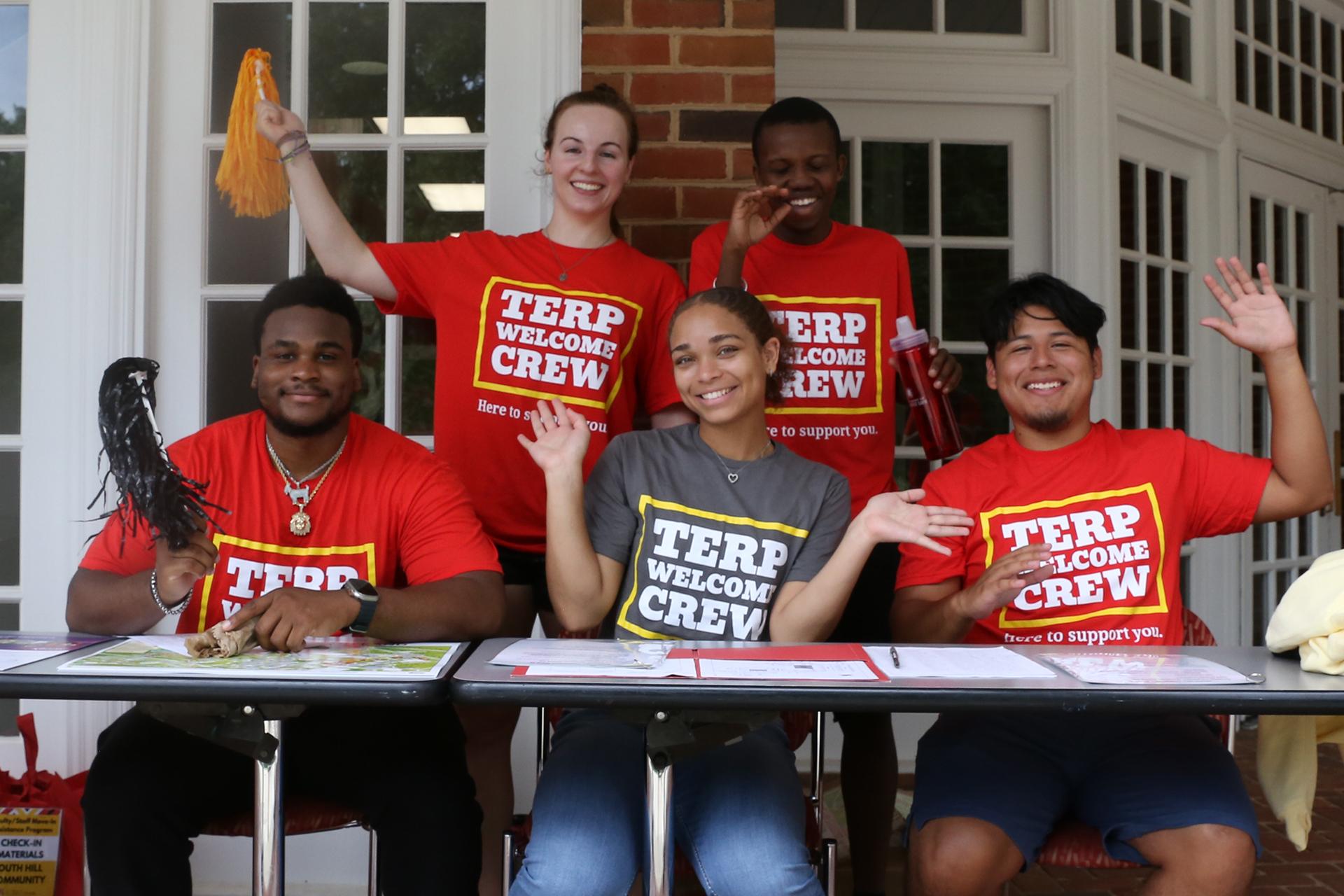 five terp welcome crew volunteers cheering at a spirit station during move-in