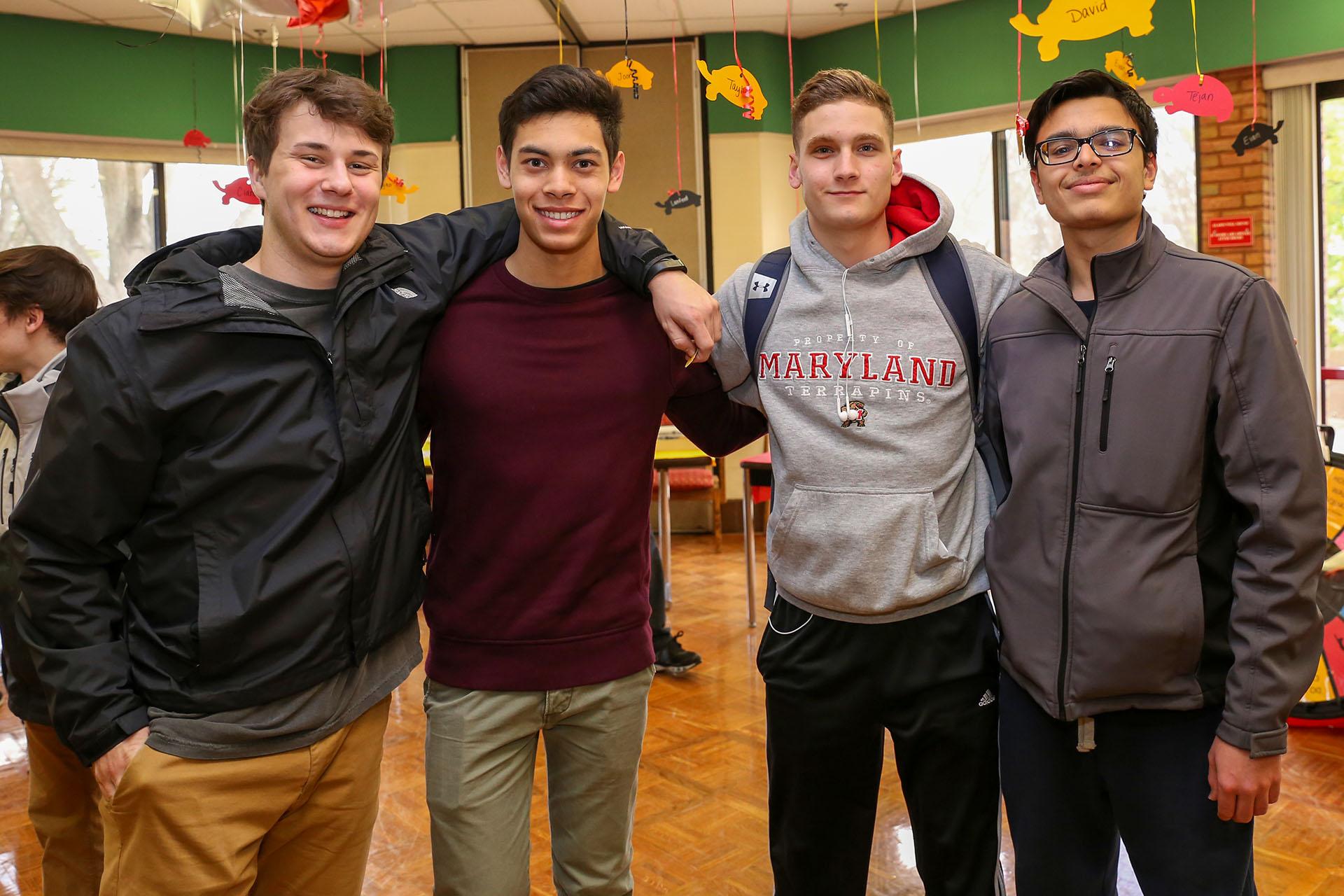 group of four male students at an event in the Leonardtown Community Center