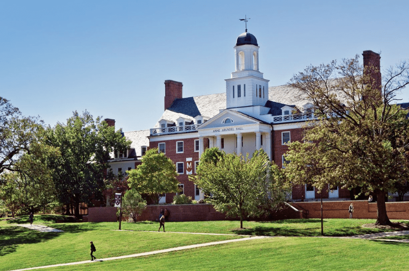 Anne Arundel Hall, a brick building with a white cupola on a green campus lawn.