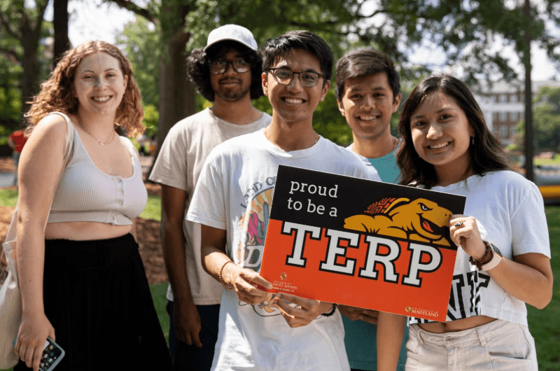 a group of student holding a proud to be a terp sign