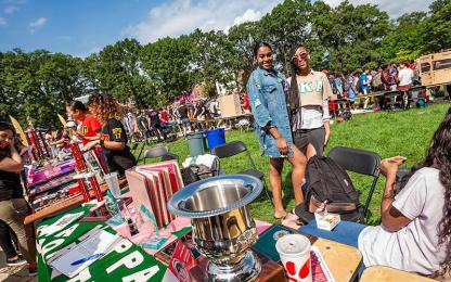two sorority students posing behind a table during the first look fair.
