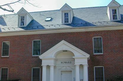 Exterior of Howard Hall, a brick building with white roof dormers and a small pillared entryway.