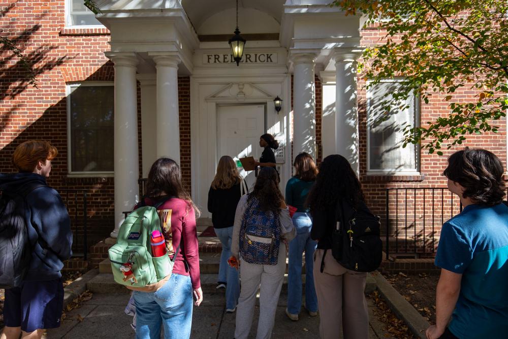 A tour guide swiping into Frederick Hall with a group of students to showcase a room during the South Campus Livin event.